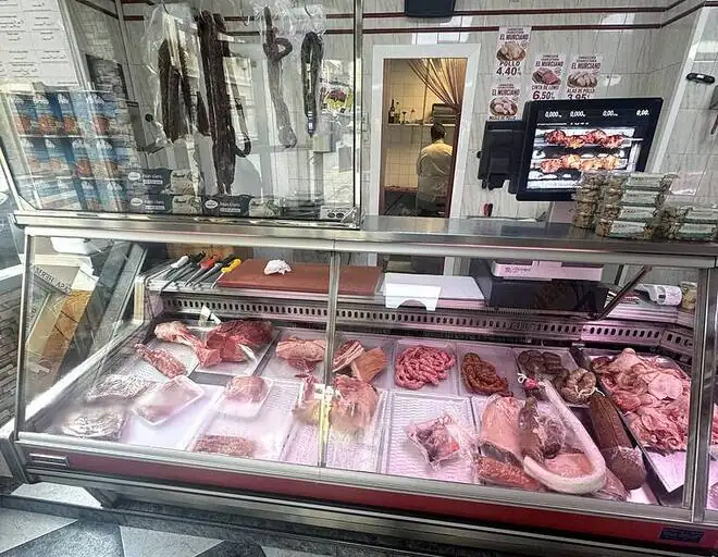 Vitrina de carne fresca con el obrador al fondo